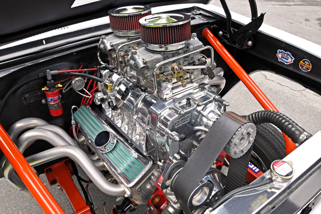 011 chrome plated engine with dual air filters red spark plug wires and tubular exhaust headers nestled in a 1966 chevy nova