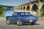 006 Blue 1967 Camaro with a river and bridge backdrop