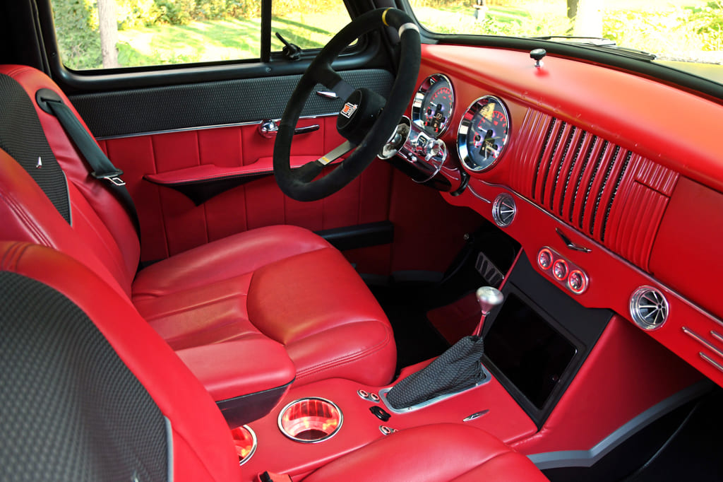 11 Interior view of a 1954 Chevy truck with red seats and matching dashboard